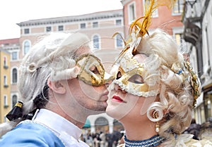 Couple kissing and dressed up for the Venice Carnival wearting contemporary clothes