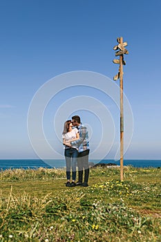 Couple kissing embraced by a direction sign