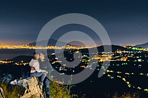 Couple kissing enjoy view from the top of the mountain to the lights of the city of Sorrento. Volcano Vesuvio. Sea and romance.