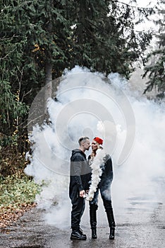 couple kissing in the fog. lovers tenderness colored smoke steam white on the path forest romance stylish passionate