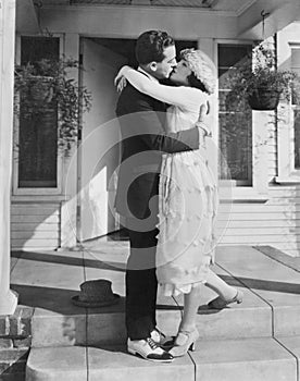 Couple kissing on front porch