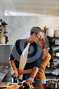 Couple kissing while making dinner