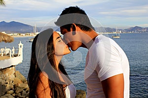 Couple kissing by the ocean