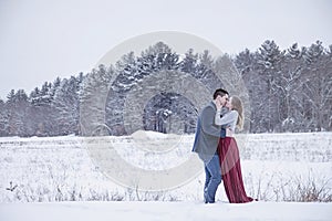 Couple kissing outdoors in winter snow