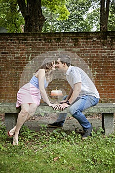 Couple kissing over cake celebrating one year anniversary