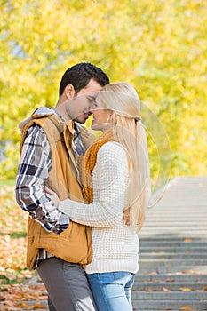 Couple kissing in park during autumn