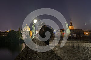 Couple kissing on prague charles bridge at night