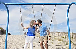 Couple kissing on swings