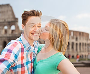 Couple kissing and taking selfie over coliseum