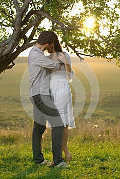 Couple kissing under tree