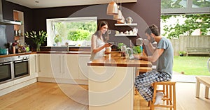 Couple, kitchen and conversation with coffee for internet meme while working from home with laptop. Dating, man and