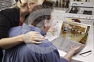 Couple In Kitchen Using Laptop - Home Improvement