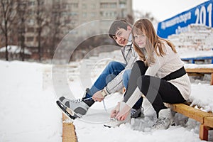 Couple lacing up the skates