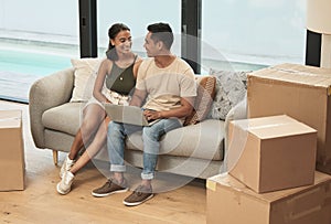 Couple, laptop and boxes for moving on couch for smile, bonding and streaming in new home. Man, woman and relax on sofa