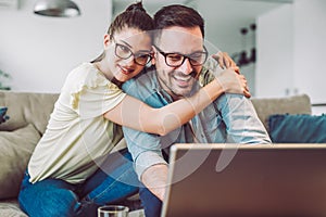 Couple with laptop spending time together at home