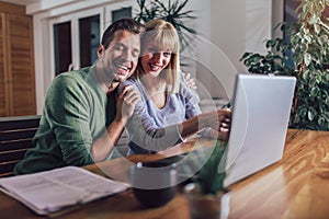 Couple with laptop spending time together at home