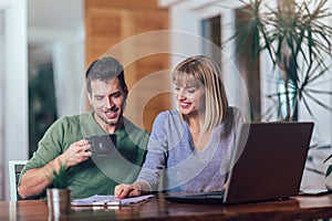 Couple with laptop spending time together at home