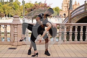 Couple of latin and bachata dancers dancing in a square. They are a young and handsome man and a beautiful woman. Dance concept