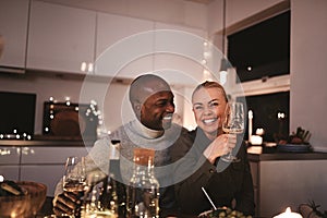 Couple laughing with friends during a candlelit dinner party