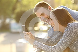 Couple laughing with media content in a phone