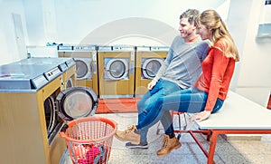 Couple in laundromat watching the laundry