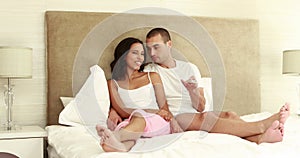 Couple laying on the bed zapping