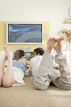 Couple Laying Down on Floor Watching TV