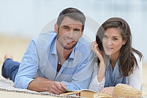 couple laying in sand at beach