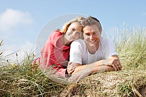 Couple laying on sand dunes