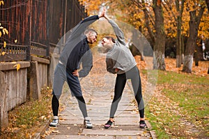 Couple are leading a healthy lifestyle doing sports exercises . Outdoors.