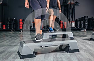 Couple legs over steppers training in aerobic