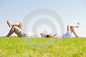 Couple lie down on grass
