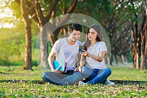Couple listening music from mobile with headphone in the park