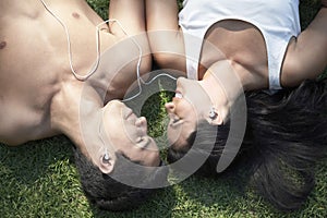 Couple Listening To Music While Lying On Grass