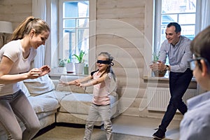 Couple with little kids playing hide and seek at home