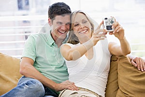 Couple in living room with digital camera