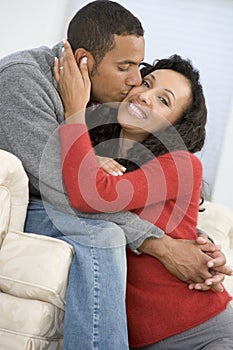 Couple in living room kissing and smiling