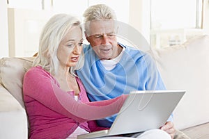 Couple in living room with laptop smiling