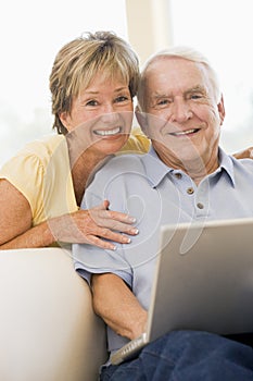 Couple in living room with laptop smiling