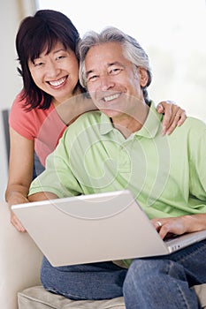 Couple in living room with laptop smiling