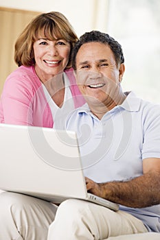 Couple in living room with laptop smiling