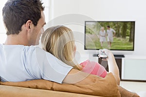 Couple in living room watching television photo