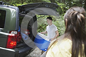 Couple Loading Car In Forest