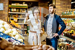 Couple with long shopping list in the supermarket