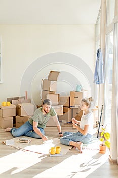 Couple looking blueprints of they new house. Planning interior design