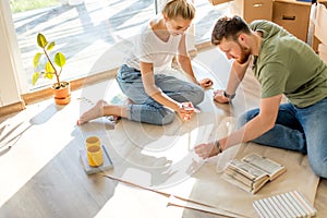 Couple looking blueprints of they new house. Planning interior design