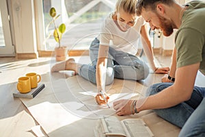 Couple looking blueprints of they new house. Planning interior design