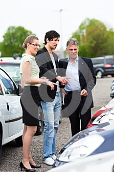 Couple looking at car on yard of dealer