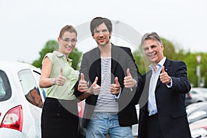 Couple looking at car on yard of dealer