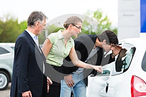 Couple looking at car on yard of dealer